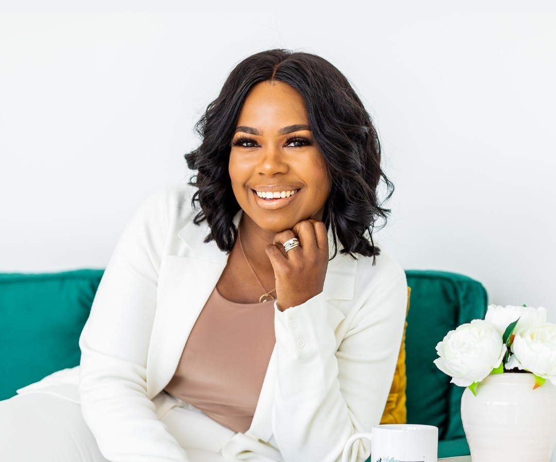 Jasmine Womack smiling in a white suit
